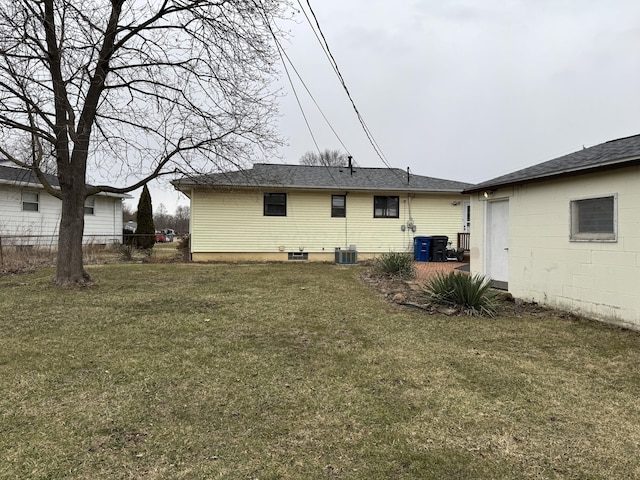 rear view of property with a yard, central AC, and fence