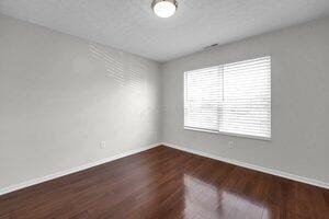 unfurnished room with baseboards and wood finished floors