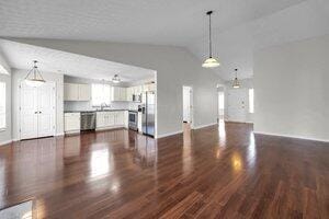 unfurnished living room with lofted ceiling and dark wood-style flooring