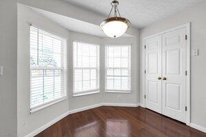 unfurnished dining area featuring a wealth of natural light, baseboards, and dark wood-style flooring