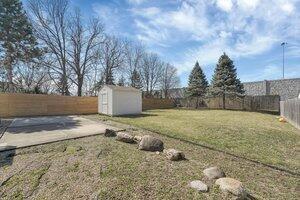 view of yard with an outbuilding, a shed, and a fenced backyard