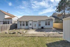 back of house featuring a patio area, a lawn, and a fenced backyard