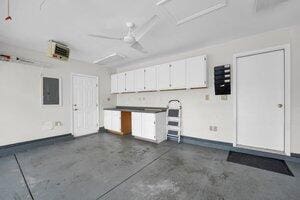 garage with electric panel and baseboards