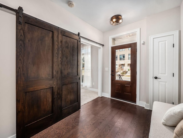 entrance foyer featuring dark wood-style floors, baseboards, and a barn door