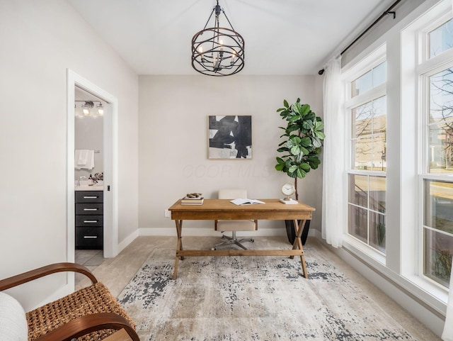 office area featuring a sink, a healthy amount of sunlight, baseboards, and a chandelier