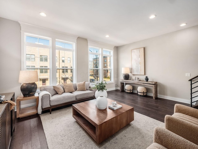 living room featuring recessed lighting, baseboards, wood finished floors, and stairs