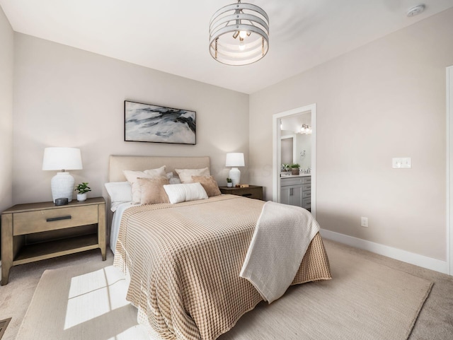 bedroom featuring light carpet, ensuite bath, and baseboards