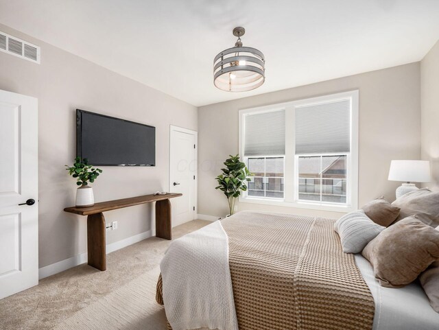 bedroom with visible vents, baseboards, and light colored carpet