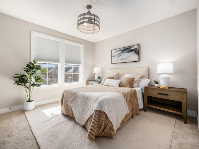 bedroom featuring light colored carpet and baseboards