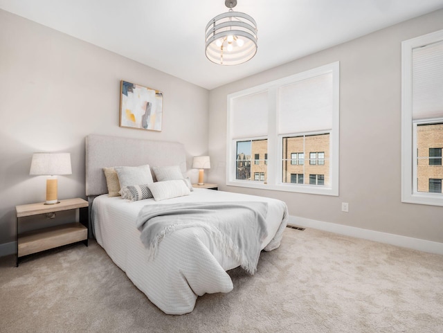 carpeted bedroom featuring visible vents and baseboards