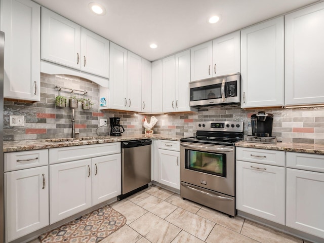 kitchen featuring light tile patterned floors, stainless steel appliances, recessed lighting, backsplash, and white cabinetry