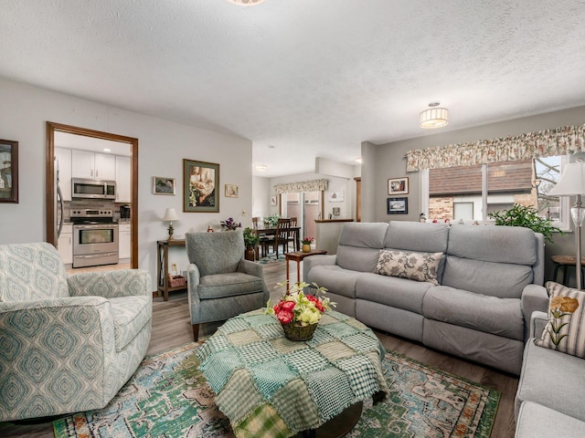 living area with a textured ceiling and wood finished floors