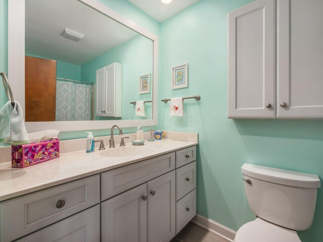 full bath featuring baseboards, visible vents, vanity, and toilet