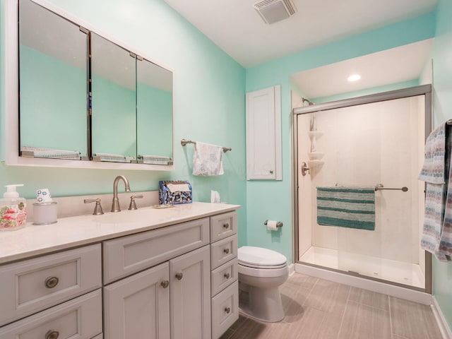 bathroom with visible vents, a shower stall, toilet, and vanity