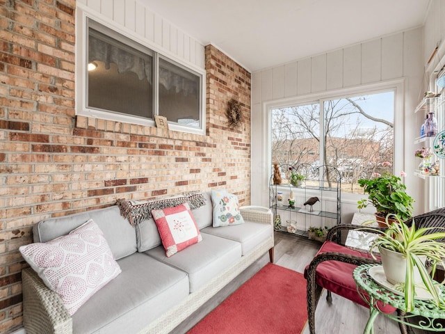 living room with brick wall and wood finished floors