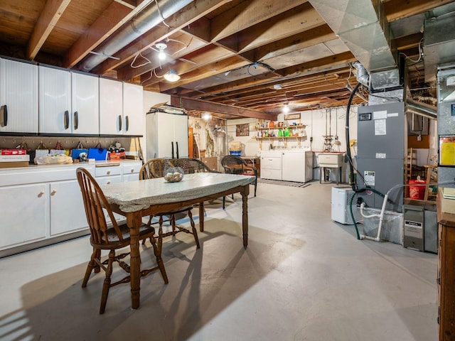 dining area with concrete flooring, washer and dryer, and heating unit