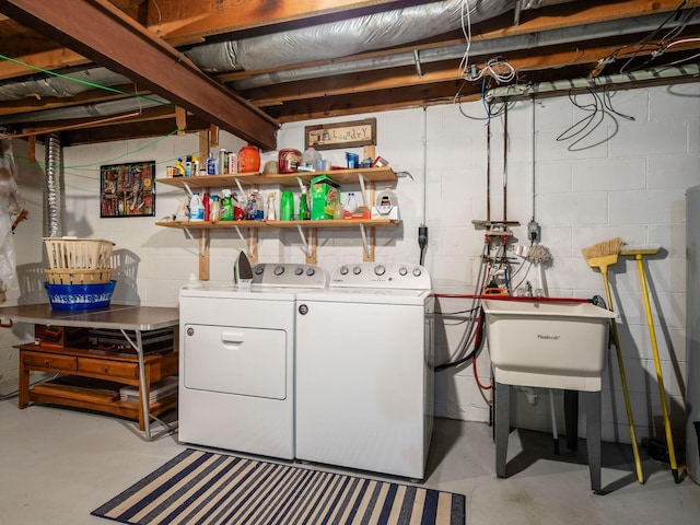 washroom with laundry area, separate washer and dryer, and a sink