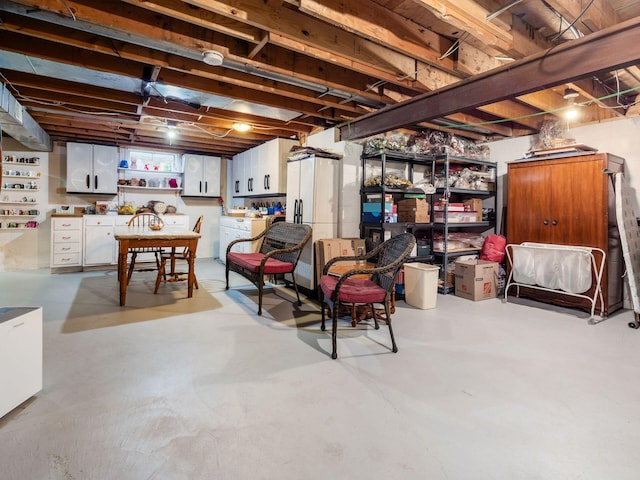 unfinished basement with washer / clothes dryer and freestanding refrigerator