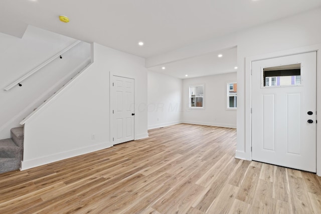 entryway featuring light wood finished floors, stairs, baseboards, and recessed lighting