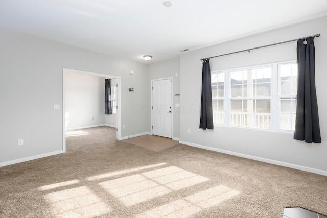 carpeted empty room featuring visible vents and baseboards