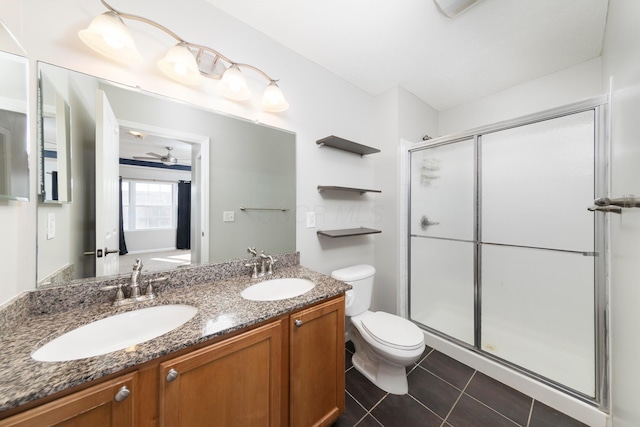 bathroom with tile patterned floors, toilet, a shower stall, and a sink