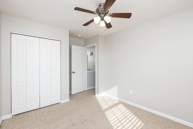 unfurnished bedroom featuring a closet, baseboards, carpet, and ceiling fan