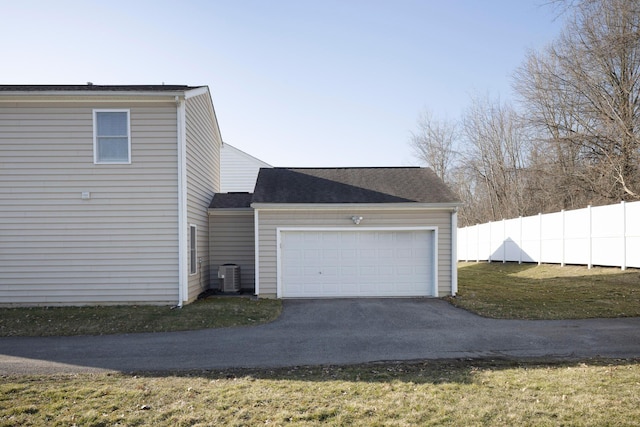 view of side of home with aphalt driveway, cooling unit, a garage, and fence