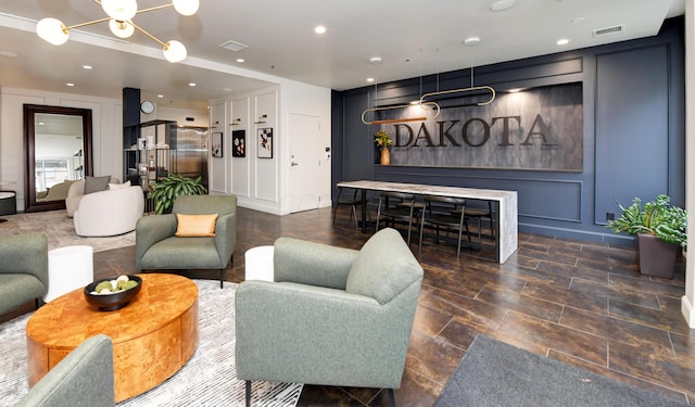 living area with recessed lighting, visible vents, a decorative wall, and a notable chandelier