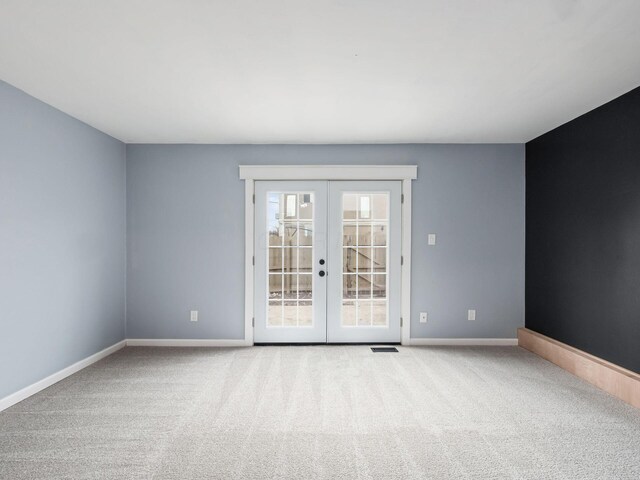 spare room with french doors, carpet flooring, visible vents, and baseboards