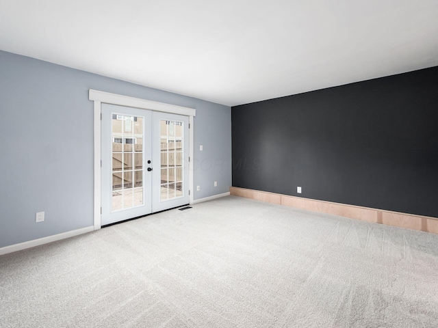 empty room featuring french doors, carpet flooring, and baseboards