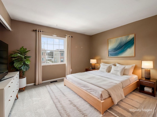 bedroom with light colored carpet, visible vents, and baseboards