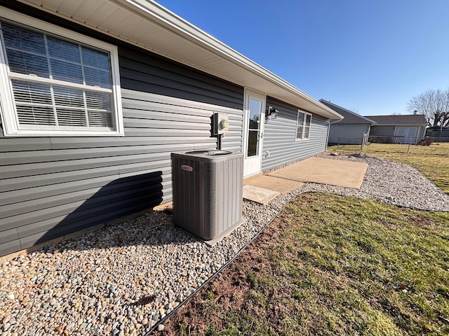 exterior space featuring electric meter, central AC, and fence