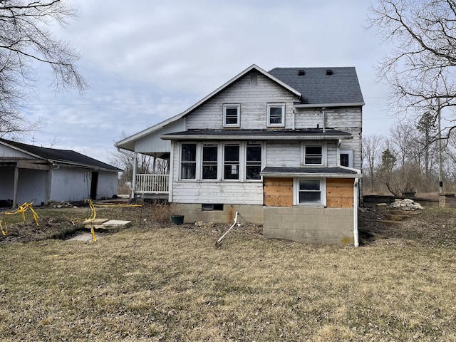 back of property featuring roof with shingles and a lawn