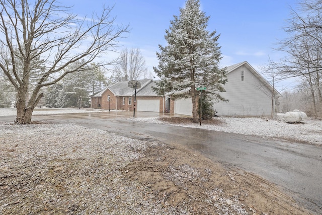 view of front of property with driveway, brick siding, and an attached garage