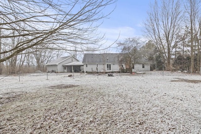 view of snow covered back of property