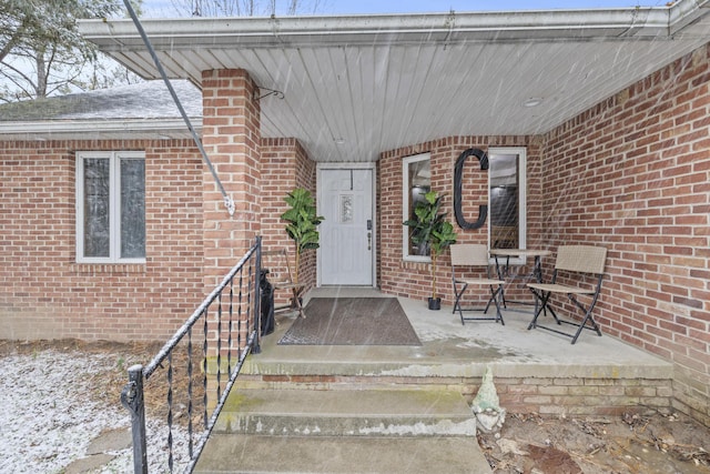 entrance to property featuring brick siding