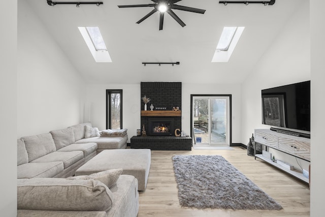 living area featuring a brick fireplace, high vaulted ceiling, baseboards, and wood finished floors