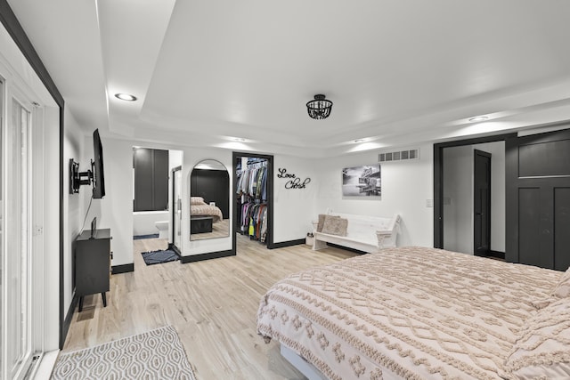 bedroom featuring light wood finished floors, visible vents, and baseboards