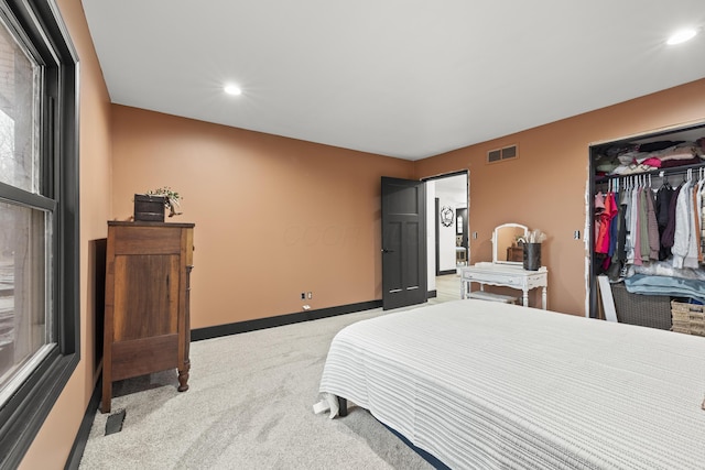 bedroom with baseboards, visible vents, recessed lighting, a closet, and light carpet