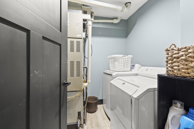 laundry area with separate washer and dryer, wood finished floors, and laundry area