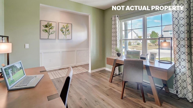 office space featuring a decorative wall, wood finished floors, and a wainscoted wall