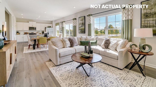 living area with recessed lighting, baseboards, and light wood-style floors