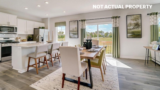 dining space featuring recessed lighting, wood finished floors, and baseboards