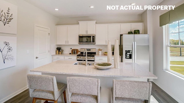 kitchen with white cabinetry, a healthy amount of sunlight, and stainless steel appliances