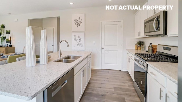 kitchen featuring a kitchen island with sink, appliances with stainless steel finishes, white cabinetry, and a sink