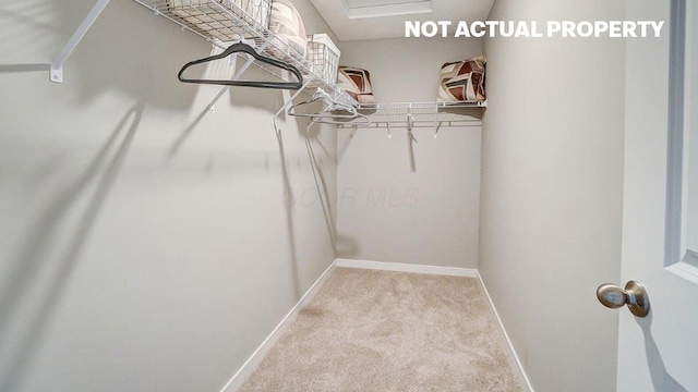 spacious closet with carpet flooring and attic access