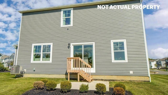 back of house featuring cooling unit and a lawn