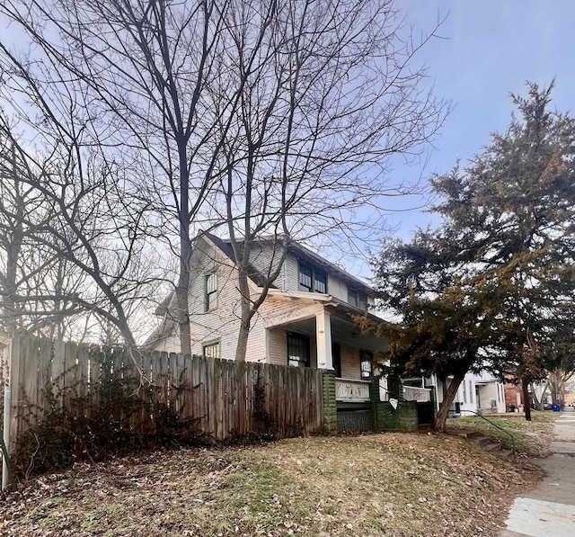 view of home's exterior with a garage, a porch, and fence