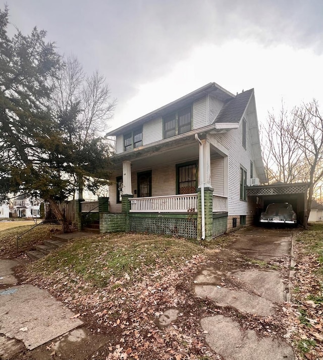 view of front of home with a carport, a porch, and concrete driveway