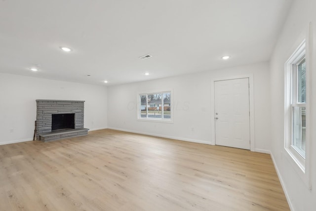 unfurnished living room featuring recessed lighting, visible vents, a fireplace, and light wood finished floors